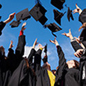 group of graduates throwing their caps in the air