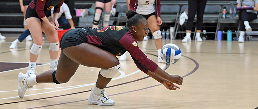 Volleyball player dives for ball.