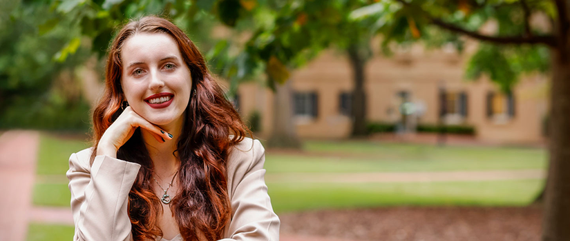 photo of a woman with redi hair smiling outside 