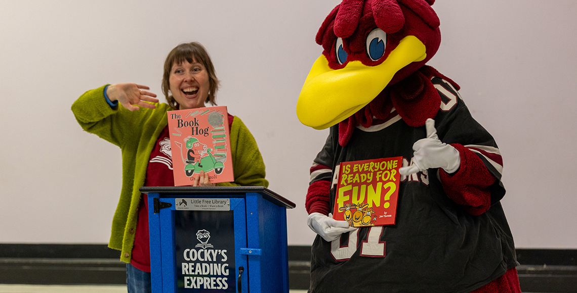 Margaret Cook Jackson and Cocky holding up books