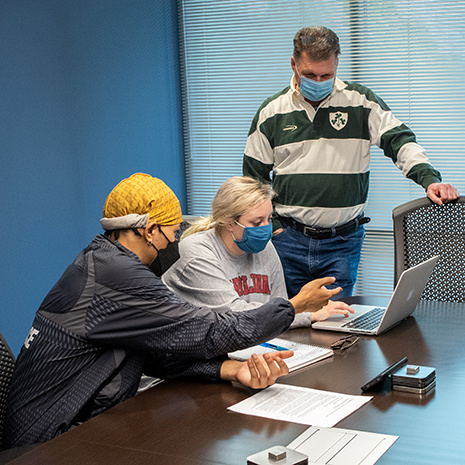 Tony Dillon works with two students at a computer