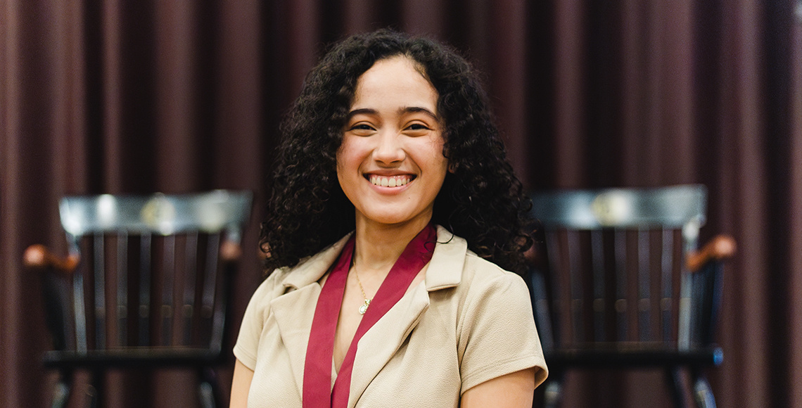 Young woman with dark curly hair smiling