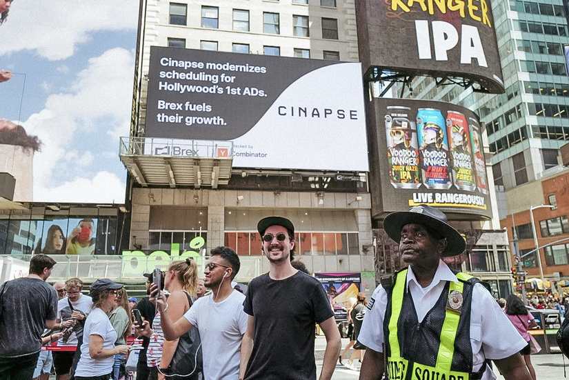 Phillips smiling in Times Square with the Cinapse billboard behind him.