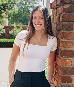 Sophia Conner leaning against a brick wall on USC's historic horseshoe.