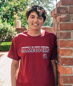 Armaan Verma leaning against a brick wall on USC's historic horseshoe.