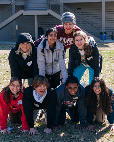 Group of Top Scholars laughing and forming a pyramid in an activity.