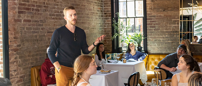 Scott Taylor Jr. speaks to students at a restaurant.