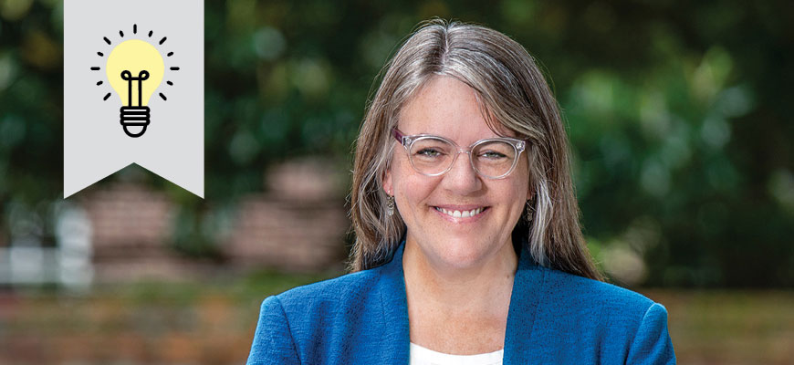 Lori Ziolkowski, wearing a blue jacket, stands in front of a brick wall