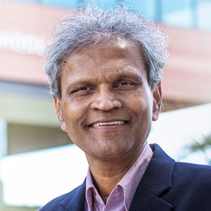 Sanjay Ahire smiles with Darla Moore School of Business in the background