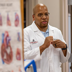 man in white coat stands in front of room