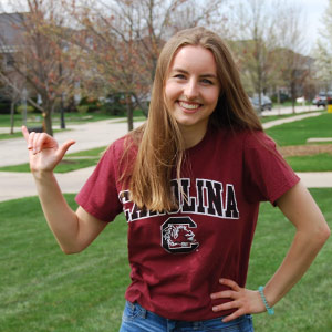 Emily Prillaman gives the spurs up sign outdoors.